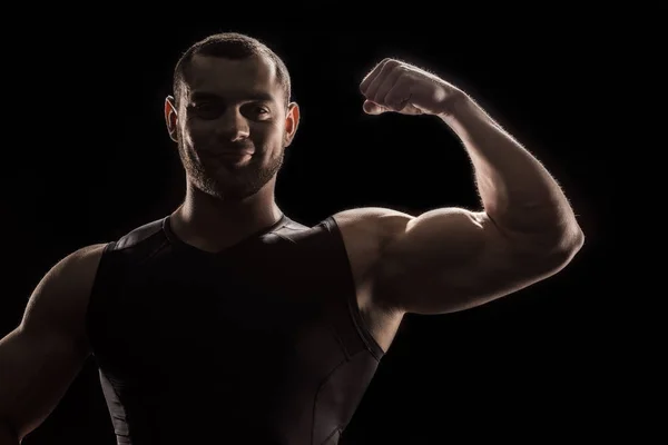 Jeune bodybuilder flexion biceps — Photo de stock