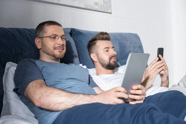 Homosexual couple using digital devices — Stock Photo