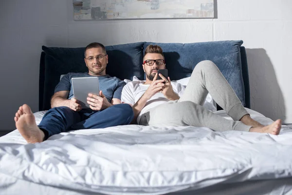 Homosexual couple using devices — Stock Photo