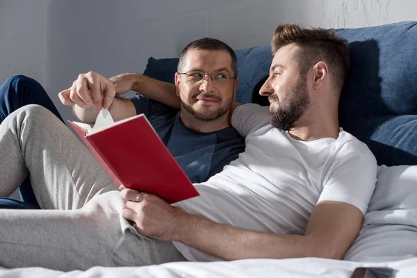 Homosexual pareja leyendo libro - foto de stock