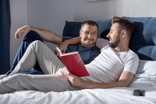 Homosexual pareja leyendo libro - foto de stock