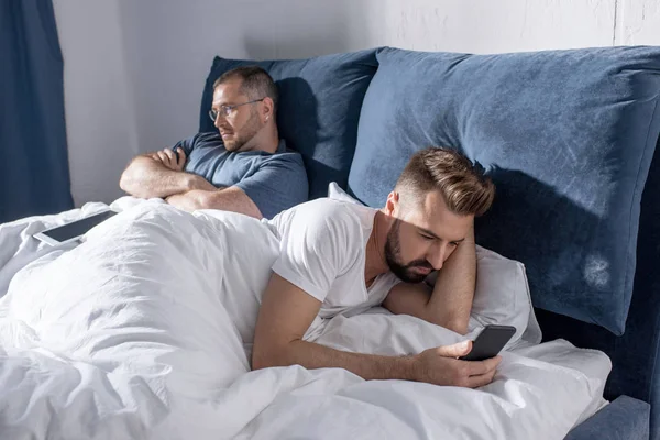 Couple homosexuel utilisant des appareils numériques — Photo de stock