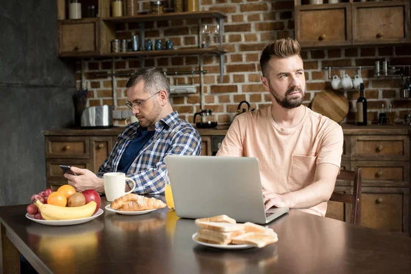 Homosexual couple using digital devices — Stock Photo