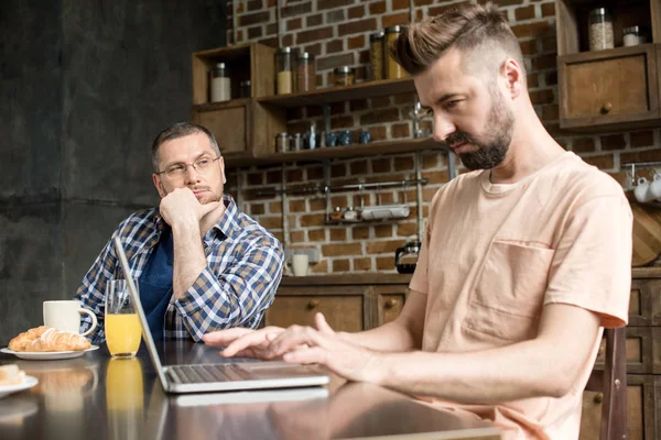 Mann benutzt Laptop beim Frühstück — Stockfoto