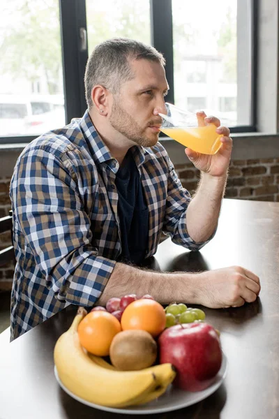 Uomo che beve succo d'arancia — Foto stock