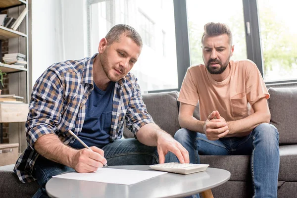 Homosexual couple counting budget — Stock Photo