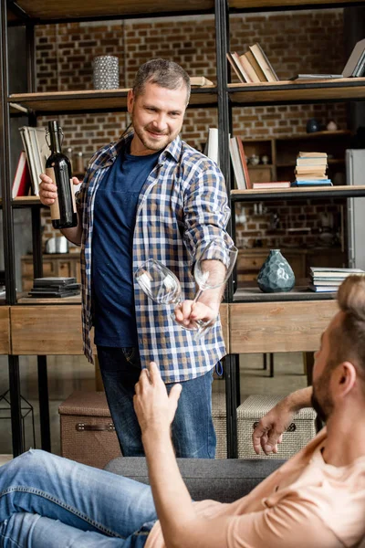 Man giving glass of wine to boyfriend — Stock Photo