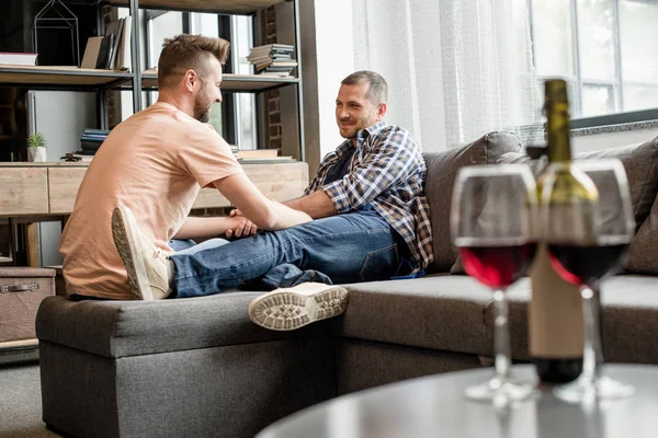 Casal homossexual beber vinho no sofá — Fotografia de Stock