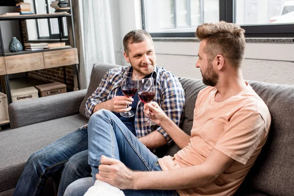 Pareja homosexual tintineo con vasos de vino — Stock Photo