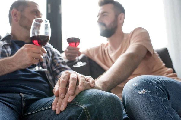 Pareja homosexual bebiendo vino durante la charla - foto de stock