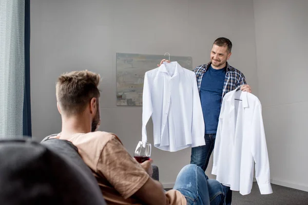 Casal homossexual escolher camisas em casa — Fotografia de Stock