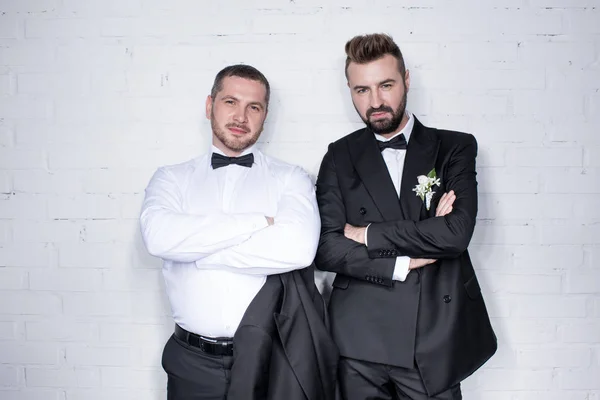 Casal de noivos posando com os braços cruzados — Fotografia de Stock