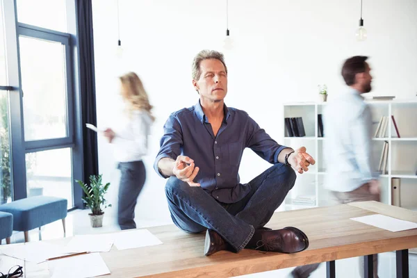 Businessman meditating in office — Stock Photo