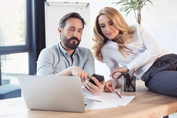 Middle aged coworkers looking at smartphone — Stock Photo