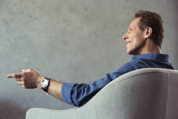 Middle aged man sitting on armchair — Stock Photo