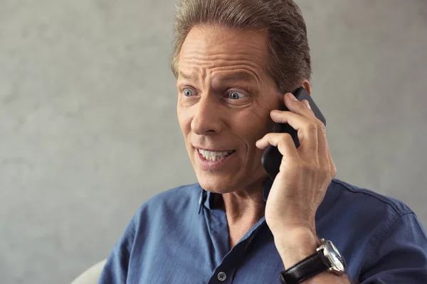 Man talking on smartphone with facial expression — Stock Photo