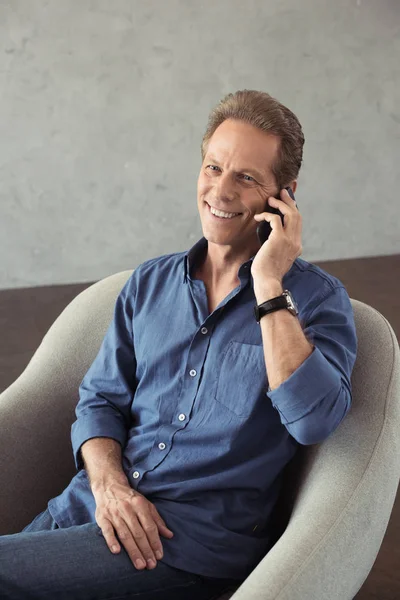 Smiling mature man talking on smartphone — Stock Photo