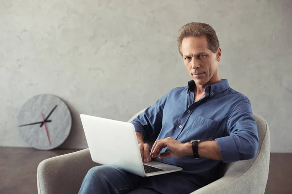 Geschäftsmann mittleren Alters arbeitet am Laptop — Stockfoto