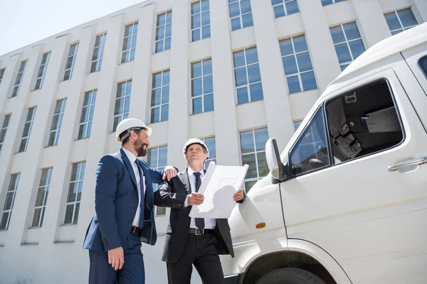 Contractors talking while standing near bus — Stock Photo