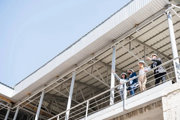 Contractors talking while standing at construction site — Stock Photo