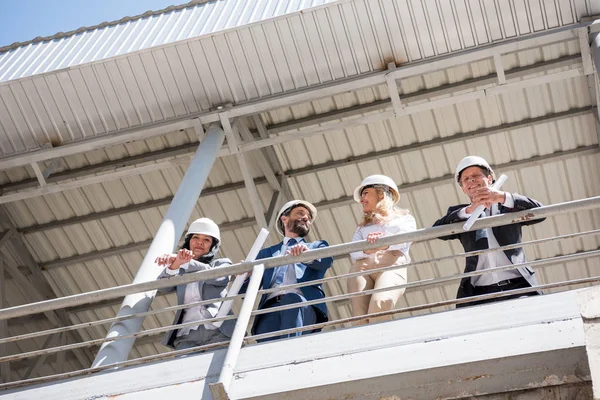 Equipo de contratistas hablando en la obra - foto de stock