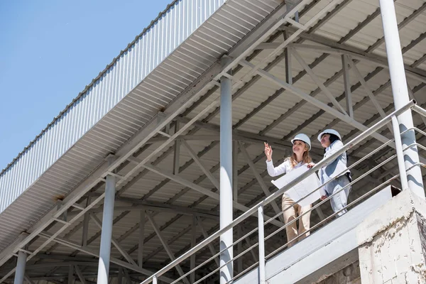 Arquitectos en ropa formal hablando en la construcción - foto de stock