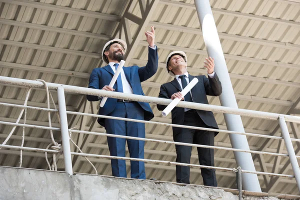 Architects in formal wear talking on construction — Stock Photo