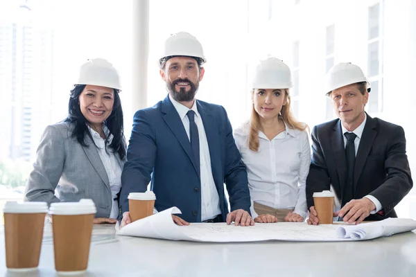 Arquitectos multiétnicos sonrientes en ropa formal - foto de stock