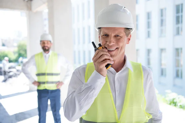 Mature constructor talking on radio set — Stock Photo