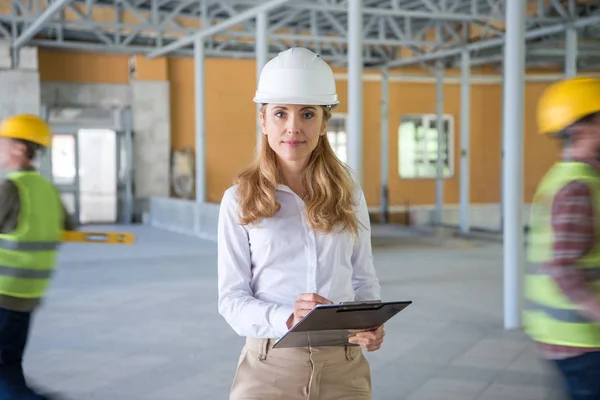 Mature contractor making notes at clipboard — Stock Photo