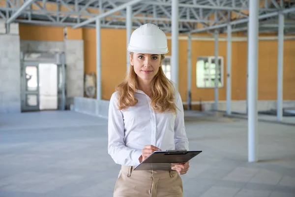 Mature contractor making notes at clipboard — Stock Photo