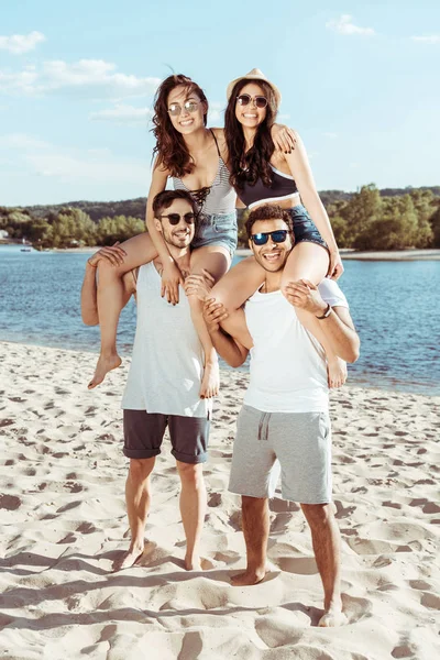 Amis piggybackking sur la plage — Photo de stock