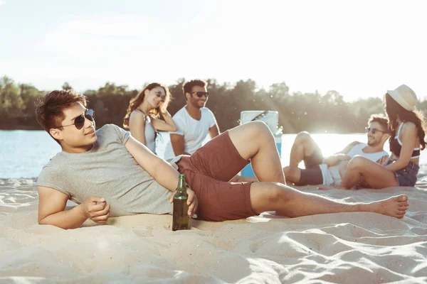 Joven acostado en la playa de arena - foto de stock