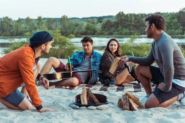 Freunde versuchen, am Strand ein Lagerfeuer zu machen — Stockfoto