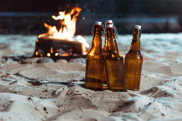 Bouteilles de bière sur la plage de sable fin — Photo de stock