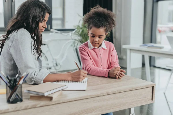 Madre aiutare figlia con i compiti — Foto stock