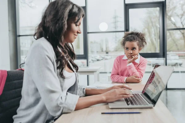 Businesswoman working with daughter — Stock Photo