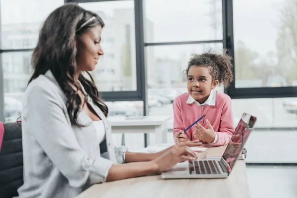 Empresaria que trabaja con su hija - foto de stock