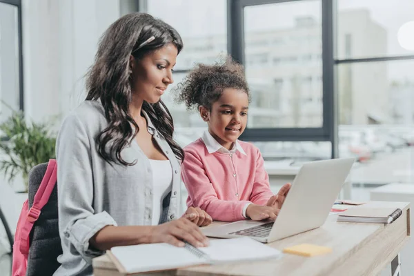 Hija ayudando a la madre con el trabajo - foto de stock