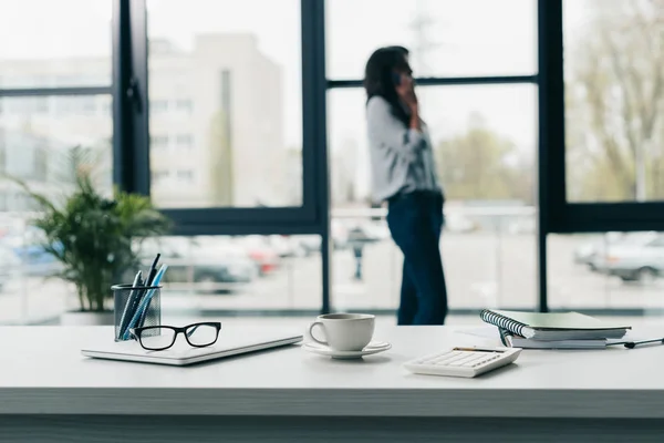 Portátil y taza de café con suministros de oficina - foto de stock