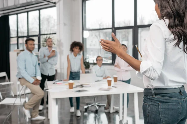 Mujer de negocios celebración de taller con colegas - foto de stock