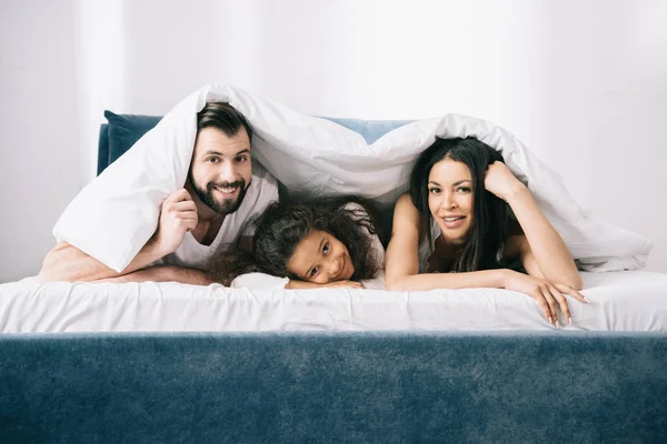 Familia feliz en el dormitorio - foto de stock