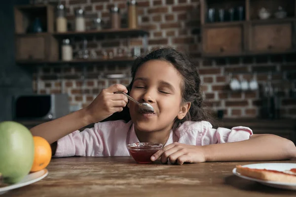 Girl eating jam — Stock Photo