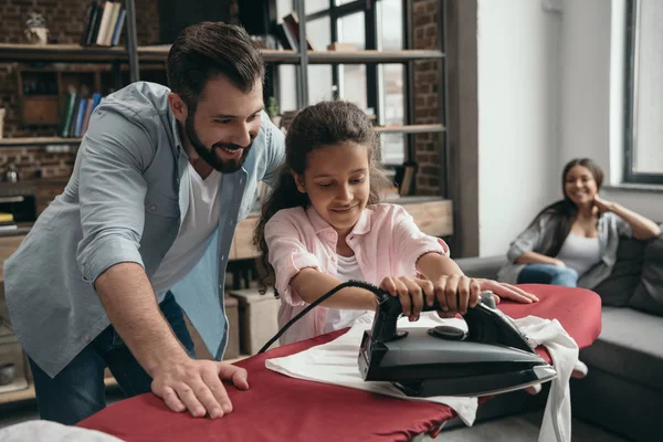Father with daughter ironing clothes — Stock Photo