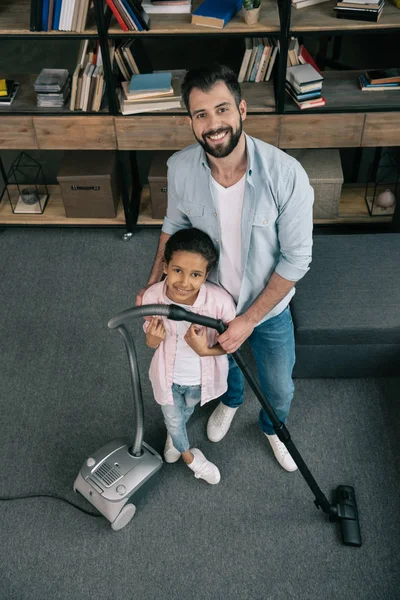 Padre e hija ordenando en casa - foto de stock