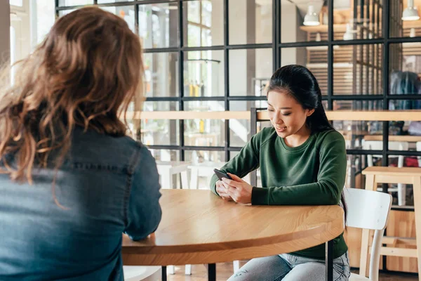 Pareja multiétnica sentada en la cafetería - foto de stock