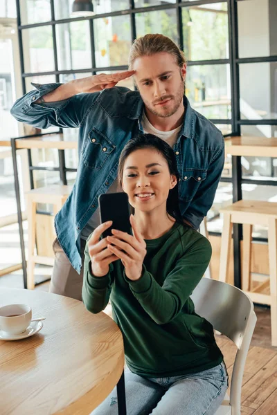 Pareja multiétnica tomando selfie en la cafetería - foto de stock