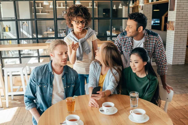 Multiethnic friends resting in cafe — Stock Photo