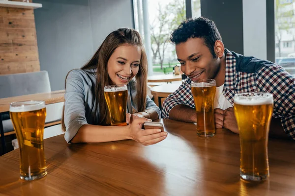 Pareja multiétnica sentada en la cafetería - foto de stock