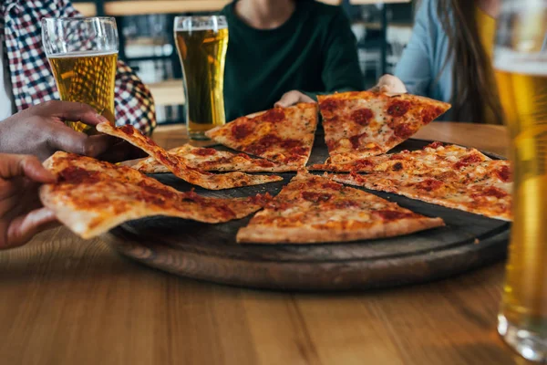 Amigos con pizza y cerveza en la cafetería — Stock Photo